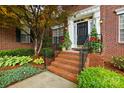 Close-up of a home's welcoming brick front entrance with landscaped steps, planters, and black front door at 1720 Mountain Park Dr, Charlotte, NC 28214