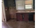 Shows a kitchen area with dated cabinets, wood paneling, a fire extinguisher, and two windows at 1769 S Nc 16 Hwy, Denver, NC 28037