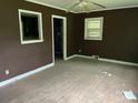 Living room with damaged hardwood floors, brown walls, and a window at 1769 S Nc 16 Hwy, Denver, NC 28037