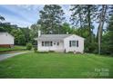Quaint, single-story home with a lush green lawn, mature trees, and a clean, white exterior at 2108 Twin Ave, Gastonia, NC 28052