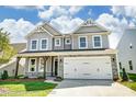Beautiful two-story home showcasing gray siding, stone accents, a two-car garage, and green lawn at 2227 Caravan Ln # 43, Denver, NC 28164