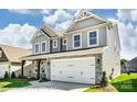 Attractive two-story home featuring gray siding, stone veneer accents, a two-car garage and manicured lawn at 2227 Caravan Ln # 43, Denver, NC 28164