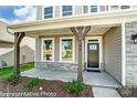 Inviting front porch with decorative wooden posts, stone accents, and a black front door with sidelights at 2227 Caravan Ln # 43, Denver, NC 28164