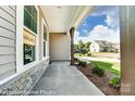 A cozy porch showcasing stone accents, sturdy wooden beams and lush landscaping at 2227 Caravan Ln # 43, Denver, NC 28164
