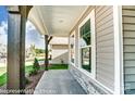 A welcoming front porch showcasing stone accents, sturdy wooden beams and lush landscaping at 2227 Caravan Ln # 43, Denver, NC 28164