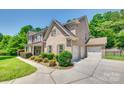 Brick home featuring a three-car garage, professionally landscaped yard and concrete driveway at 2785 Disney Pl, Indian Land, SC 29707