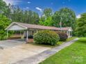 Low angle front view of a well-maintained single-story home with mature landscaping and an attached carport at 310 Yarbro Rd, Kings Mountain, NC 28086