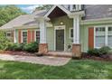 Inviting front entrance featuring brick accents, a green door, and a well-maintained landscaped walkway at 3916 Blowing Rock Way, Charlotte, NC 28210