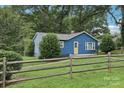 Quaint blue single story house with a wooden fence and well-maintained lawn at 407 Cherry St, Belmont, NC 28012