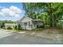 Quaint single-story home with red shutters, complemented by mature trees and a well-maintained lawn at 435 Sixteenth St, Cramerton, NC 28032