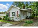 Attractive single-story home featuring a covered porch, red shutters, and manicured landscaping for welcoming appeal at 435 Sixteenth St, Cramerton, NC 28032