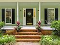 Charming front porch with brick steps, potted plants, and a decorative door sign at 4848 Spicewood Dr, Charlotte, NC 28227