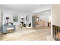 Bright, open-concept living room with hardwood floors, modern fireplace, and updated kitchen access at 4913 Seacroft Rd, Charlotte, NC 28210