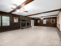 Spacious living room featuring a stone fireplace, wood paneling, and ample natural light at 5109 Goldcrest Dr, Indian Trail, NC 28079
