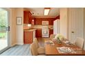 Well-lit kitchen and dining area with wooden cabinets, modern appliances, and sleek flooring at 5436 Scarlet Sage Dr, Charlotte, NC 28215