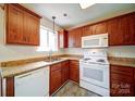 Functional kitchen with wooden cabinetry, granite countertops, and stainless steel appliances at 5436 Scarlet Sage Dr, Charlotte, NC 28215