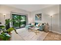 Bright living room with modern decor, stylish furniture, and a sliding glass door leading to a balcony at 715 N Church St # 310, Charlotte, NC 28202