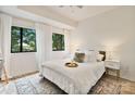 A bright main bedroom features a plush bed, side tables, and sunlit windows with sheer curtains at 715 N Church St # 310, Charlotte, NC 28202