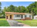 Single-story home featuring a convenient carport, light siding, and a front yard at 798 Wilson St, China Grove, NC 28023