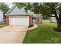 Two-story home with brick facade, attached garage, and neat landscaping at 8906 Pickering Grove Ln, Charlotte, NC 28216