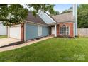 Beautiful home featuring brick and light blue siding, landscaped yard, and a paved walkway to the front door at 8906 Pickering Grove Ln, Charlotte, NC 28216