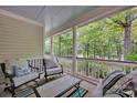Relaxing covered porch with comfortable seating, perfect for enjoying the serene wooded view at 104 Edgewater Park St, Davidson, NC 28036