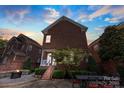 Charming brick home featuring a cozy backyard with a fireplace and outdoor dining area, perfect for entertaining at 108 Forrester Ave, Belmont, NC 28012
