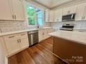 Bright kitchen features white cabinets, stainless steel appliances, white subway tile backsplash and hardwood floors at 1143 Journey Ln, Salisbury, NC 28146