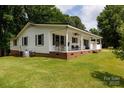 A charming single-story home with a covered front porch, lush lawn, and mature trees surrounding the property at 1197 Fincher Rd, Fort Lawn, SC 29714