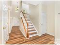 Hallway featuring hardwood floors, a staircase, and natural light, creating a welcoming atmosphere at 13305 Mallard Landing Rd, Charlotte, NC 28278