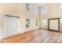 Bright living room with soaring ceilings, large windows, and elegant hardwood floors at 13305 Mallard Landing Rd, Charlotte, NC 28278