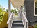 Inviting covered porch with gray stairs, white railings and house number at 2017 Brewton Dr, Charlotte, NC 28206