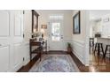 Inviting entryway featuring hardwood floors, white wainscoting, a decorative rug, and a view of the kitchen at 2066 Vermount Way, Indian Land, SC 29707