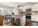 Bright kitchen with stainless steel appliances, granite counters, an island with seating, and wood floors at 2066 Vermount Way, Indian Land, SC 29707