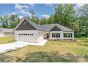 Charming single-story home with a white exterior, a dark shingled roof and an attached two-car garage at 2705 Enon Church Rd, Salisbury, NC 28147