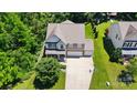 Two-story home boasts a spacious driveway, lush lawn, and mature trees for a serene setting at 3106 Crosswind Dr, Fort Mill, SC 29707