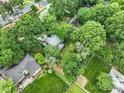 A high angle shot reveals rooftops nestled among vibrant green trees, showcasing the property's secluded location at 3327 Archdale Dr, Charlotte, NC 28210