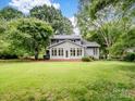 Charming home exterior with a bright sunroom, surrounded by lush green landscaping, offering serene outdoor living at 3327 Archdale Dr, Charlotte, NC 28210