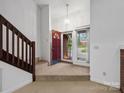 Inviting entryway with staircase, chandelier, and view to the outside through glass door at 3327 Archdale Dr, Charlotte, NC 28210