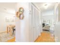 Hallway featuring hardwood floors, a dining area, storage, and a view into the living room at 3615 Maple Glenn Ln, Charlotte, NC 28226