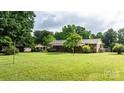 Spacious backyard with lush greenery and a charming outbuilding for storage at 518 W School St, Maiden, NC 28650