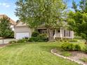 Inviting two-story home with lush green lawn, mature trees, and a charming front porch at 6533 Derby Nw Ln, Concord, NC 28027