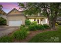 Charming home with a well-maintained lawn, mature landscaping, and a cozy front porch at 6533 Derby Nw Ln, Concord, NC 28027