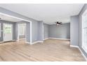 Bright living room with light wood floors, neutral walls, a ceiling fan and multiple windows at 7118 April Ridge Ln, Charlotte, NC 28215