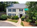 Charming condo with black shutters, green awning, and walkway leading to the front entrance at 8356 Meadow Lakes Dr, Charlotte, NC 28210