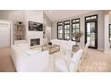 Bright living room with fireplace, built-in shelves, large windows, and contemporary furnishings at 0000 Woodhill Cove Ln # 5, Denver, NC 28037