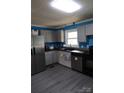 The kitchen has grey cabinets, stainless steel appliances, and wood-look floors at 145 Honeycutt Rd, Salisbury, NC 28144