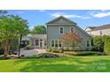 Beautiful backyard featuring a screened-in porch, manicured lawn, and mature landscaping at 16909 Red Cow Rd, Charlotte, NC 28277