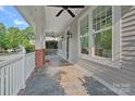 Inviting front porch featuring classic columns, tile flooring, and stylish exterior lighting fixtures at 16909 Red Cow Rd, Charlotte, NC 28277
