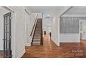 Spacious hallway with hardwood floors, elegant trim, and a staircase leading to the upper level at 16909 Red Cow Rd, Charlotte, NC 28277